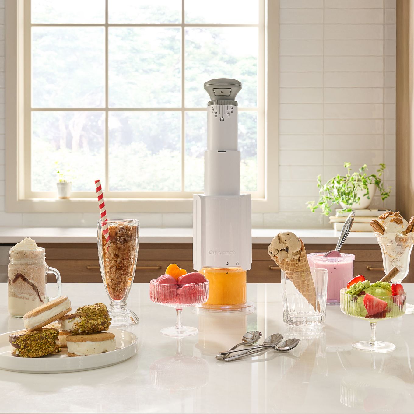 Cuisinart FastFreeze Max ICE-FD50 in white on a kitchen counter, freeze wand upright, surrounded by sorbet, milkshakes, slushies, and ice cream sandwiches it makes