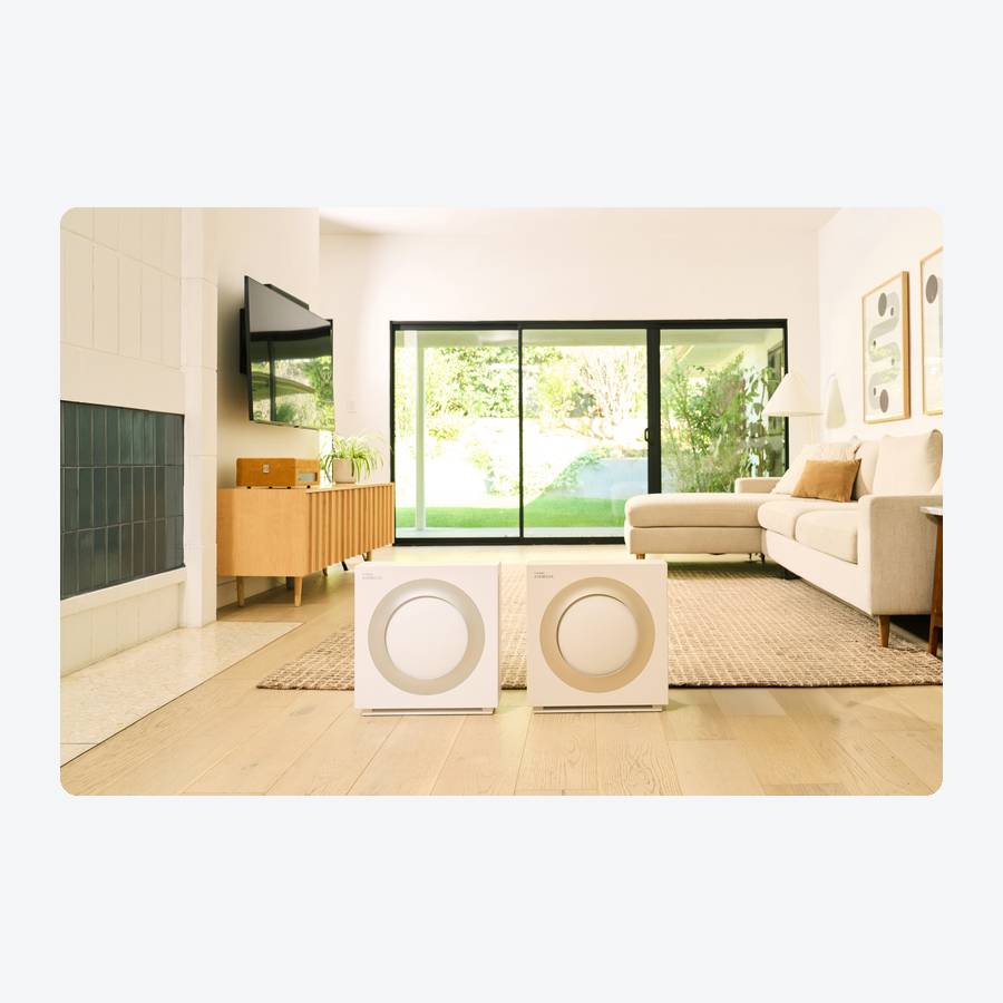 Two Coway Airmega Mighty2 AP-1512N air purifiers in white and beige on a living room floor, official launch photo