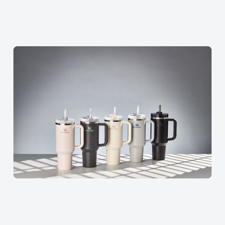 Five Stanley Quencher H2.0 FlowState 40-ounce tumblers in a row in launch colorways, each with handle and straw